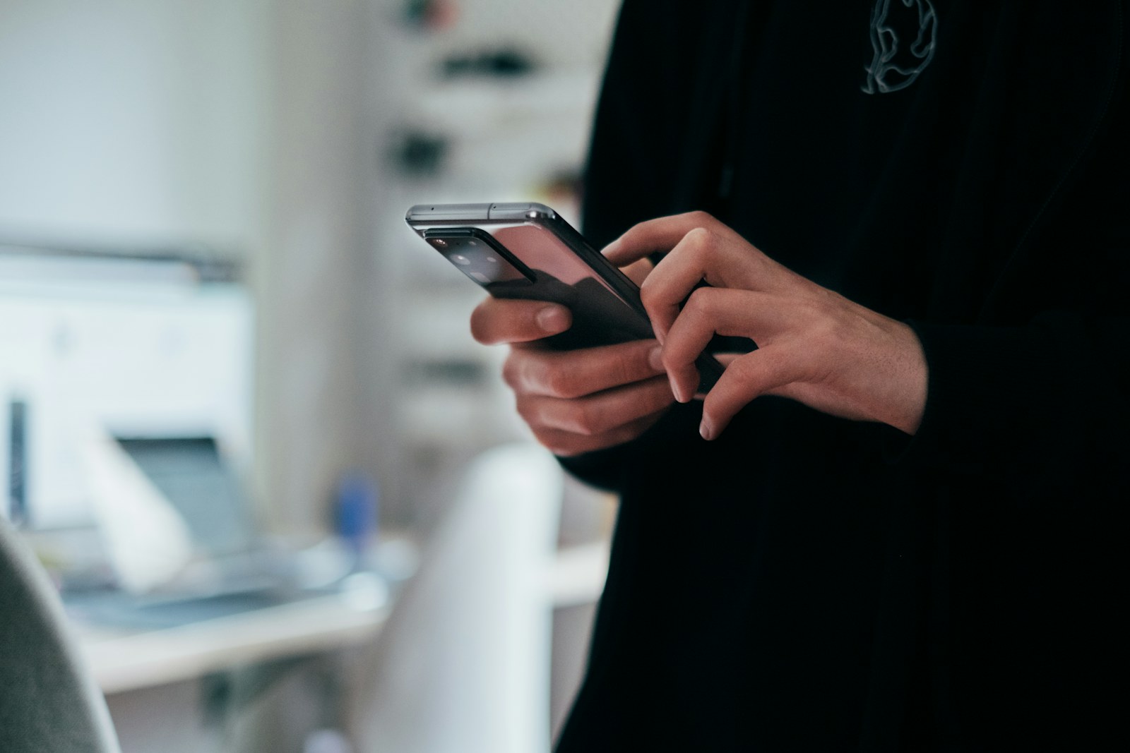 Elinde telefonuyla gelen mesajı anında kontrol eden biri, ofis ortamında